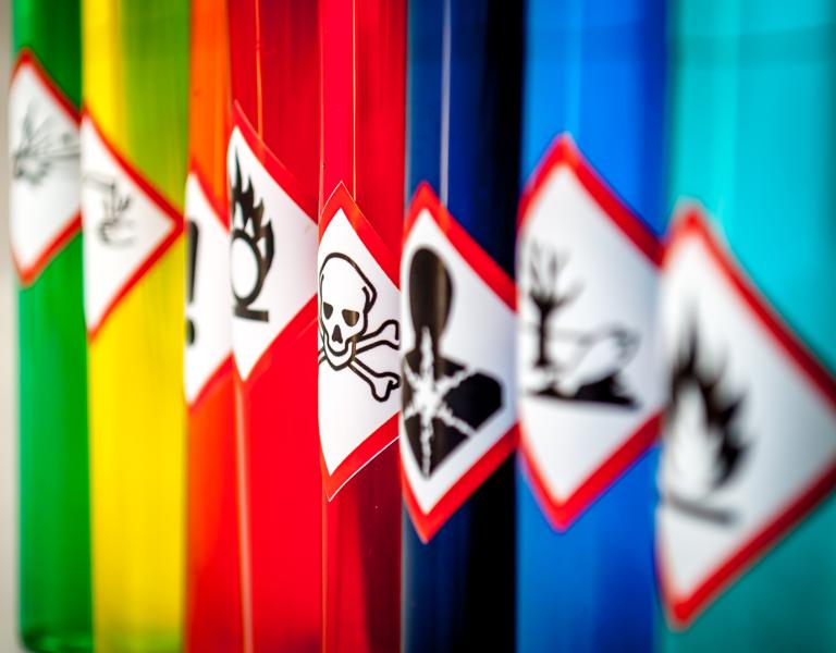 Collection of canisters with hazard warning stickers.